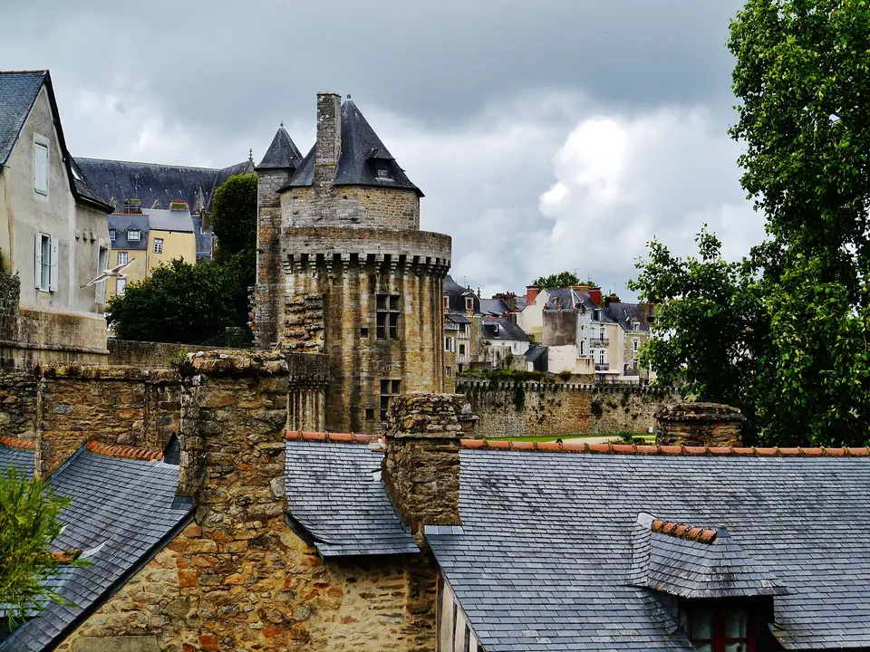 Remparts de Vannes avec une tour d'enceinte et, au premier plan, des toits en ardoise et des lucarnes de la vieille ville.